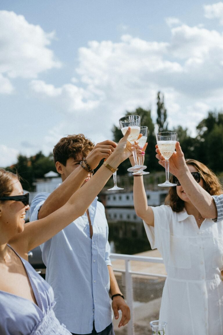 Group of friends celebrating on a yacht with champagne under a sunny sky.