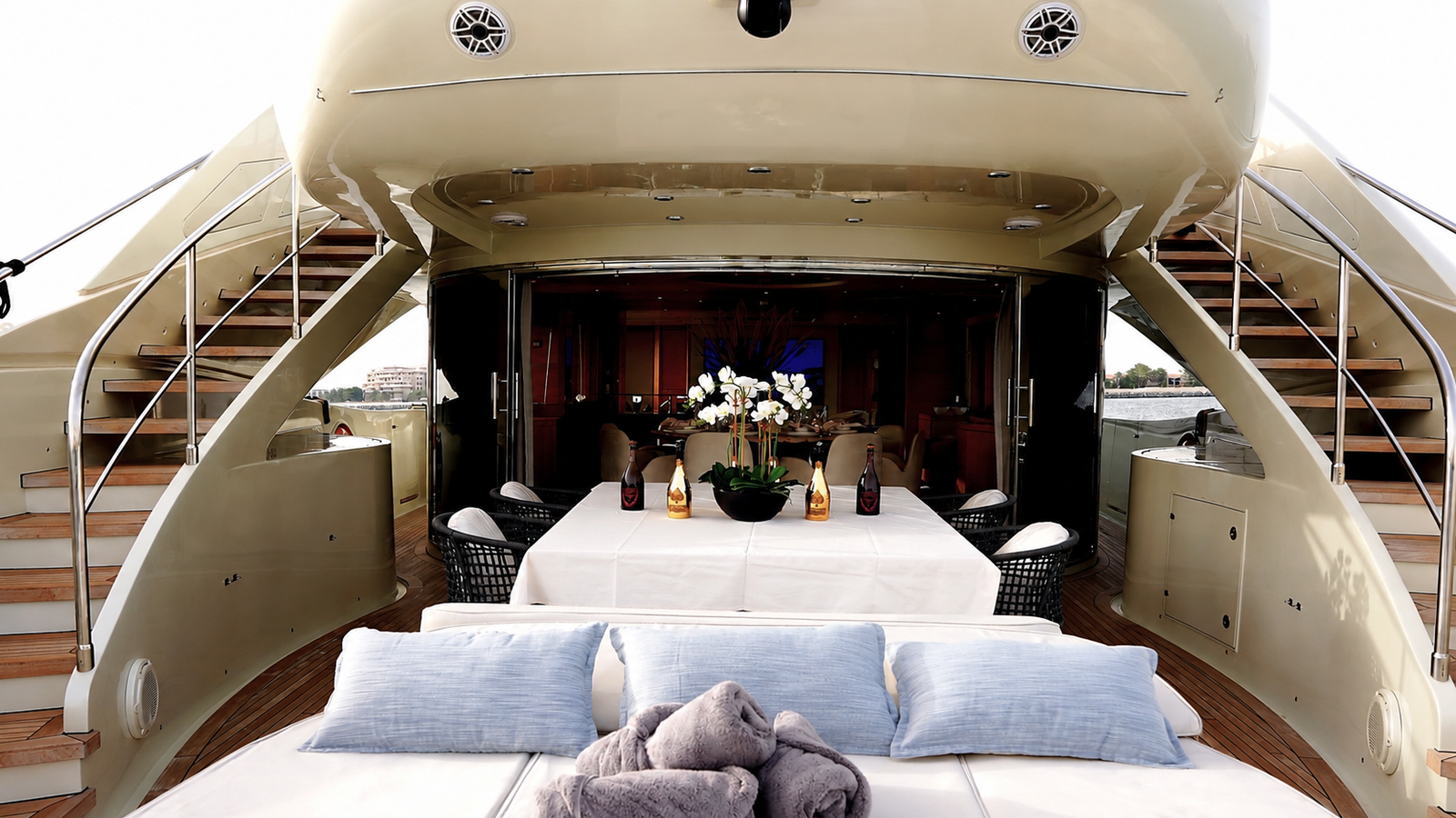 Private sundeck with cushioned loungers and towels overlooking Dubai waterfront